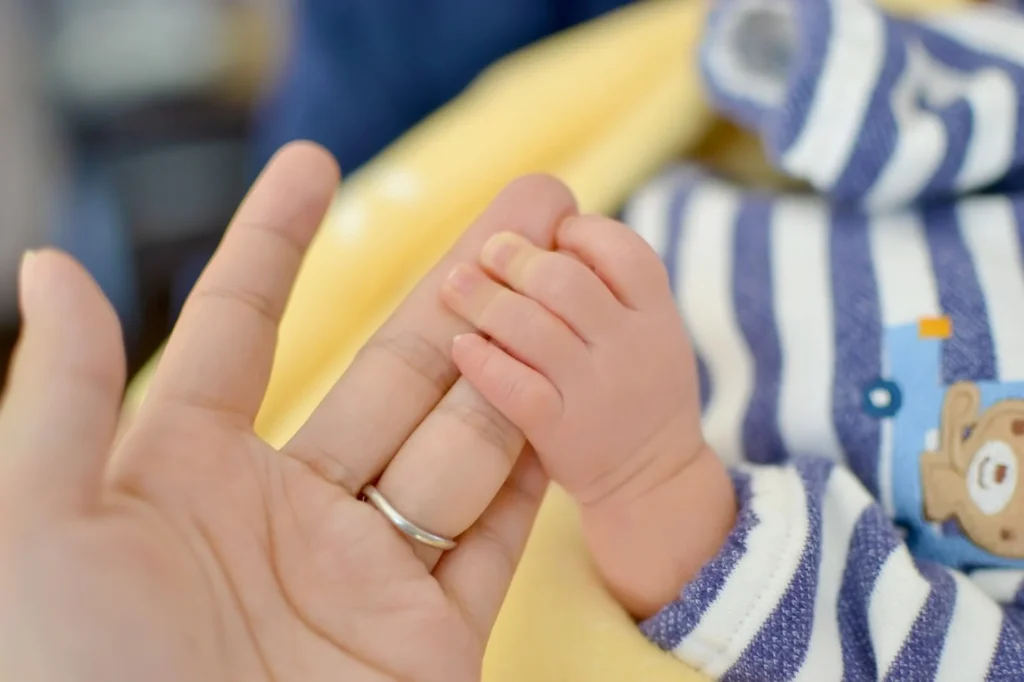 大人の手を握る赤ちゃんの手